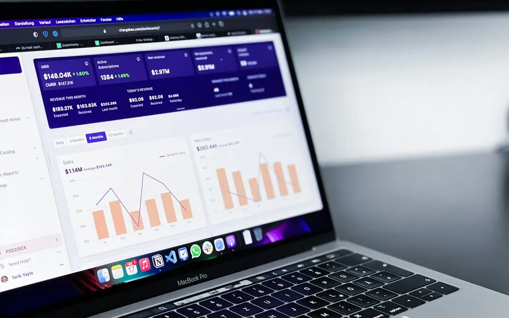 Analytics dashboard with revenue and sales charts open on a laptop